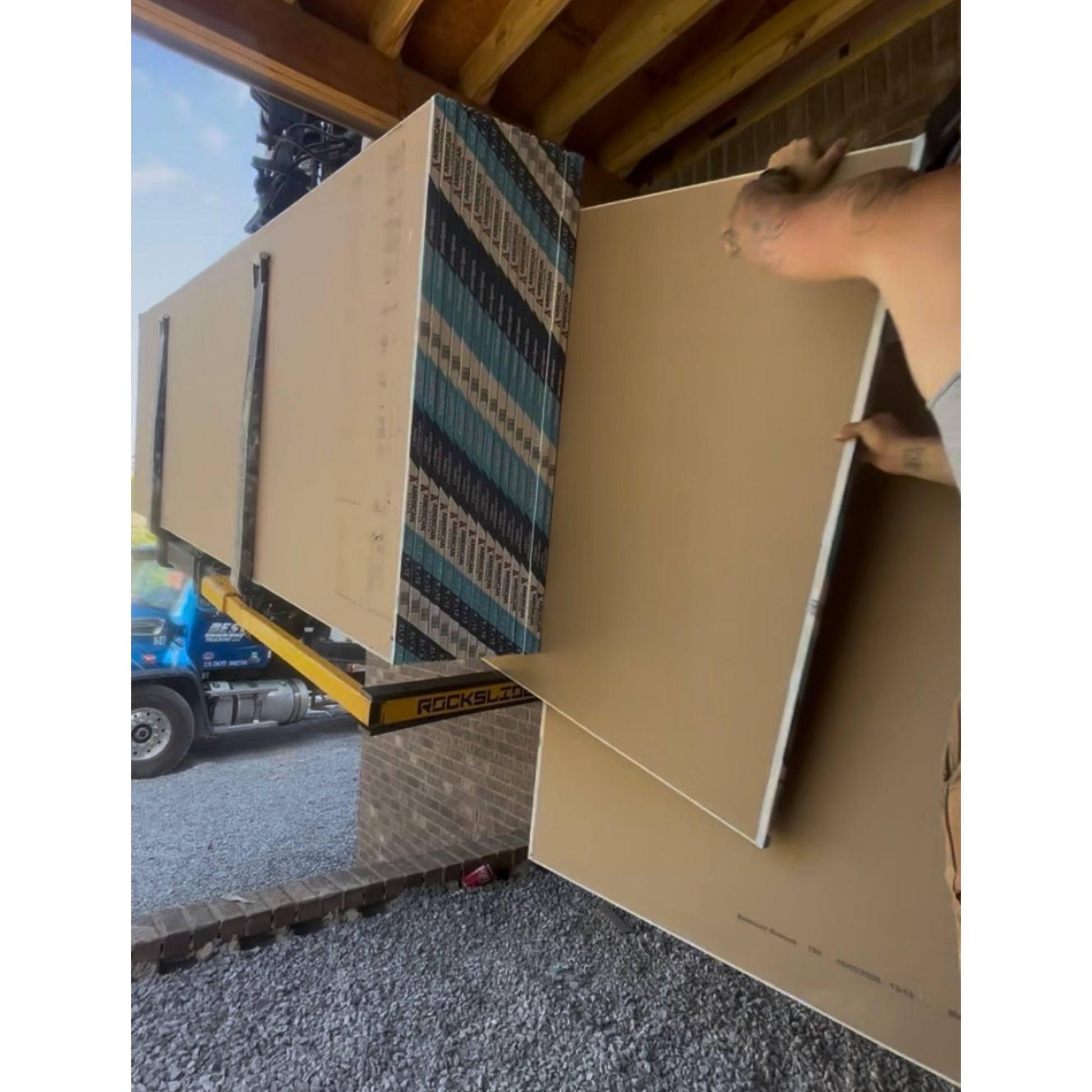 Rockslide transferring drywall from a boom fork through a doorway